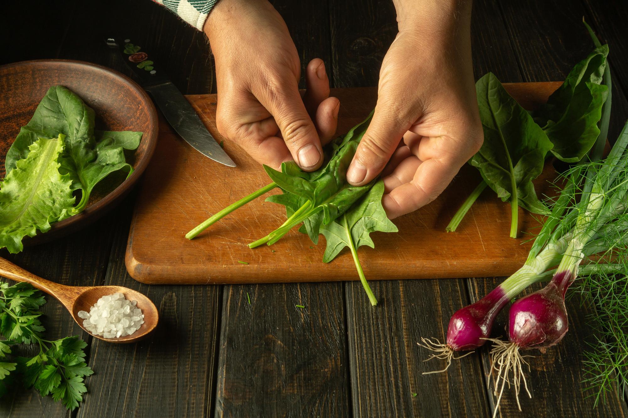 Close-up of hands chopping herbs